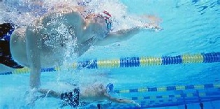 Two competitive swimmers racing in a swimming pool underwater view